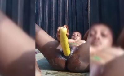 An eager girl using a big cucumber